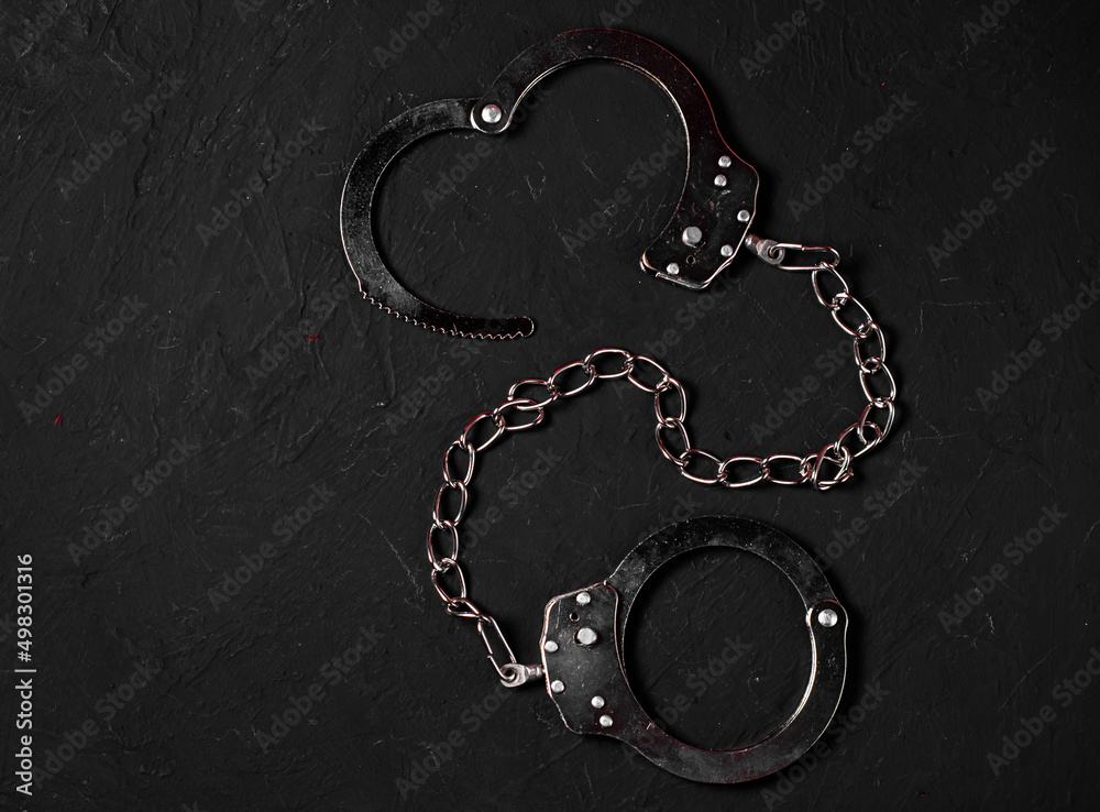 One Pair of Handcuffs on a Black Background