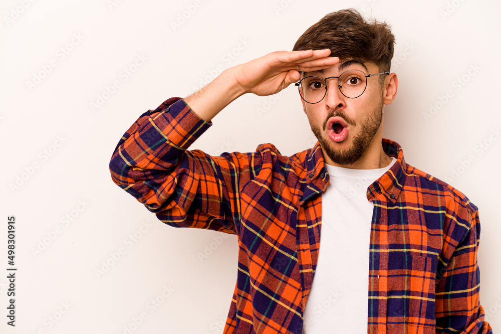 Young hispanic man isolated on white background looking far away keeping hand on forehead. Young hispanic man isolated on white background looking far away keeping hand on forehead.