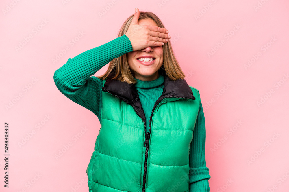 Young caucasian woman isolated on pink background covers eyes with hands, smiles broadly waiting for a surprise. Young caucasian woman isolated on pink background covers eyes with hands, smiles broadly waiting for a surprise.