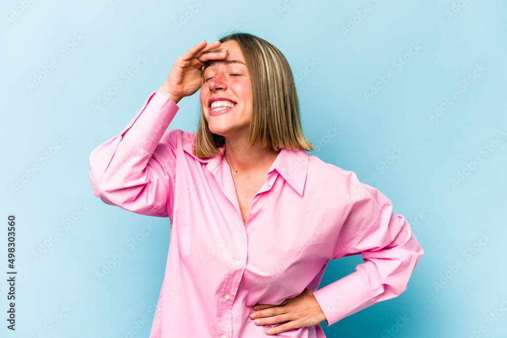 Young caucasian woman isolated on blue background joyful laughing a lot. Happiness concept. Young caucasian woman isolated on blue background joyful laughing a lot. Happiness concept.