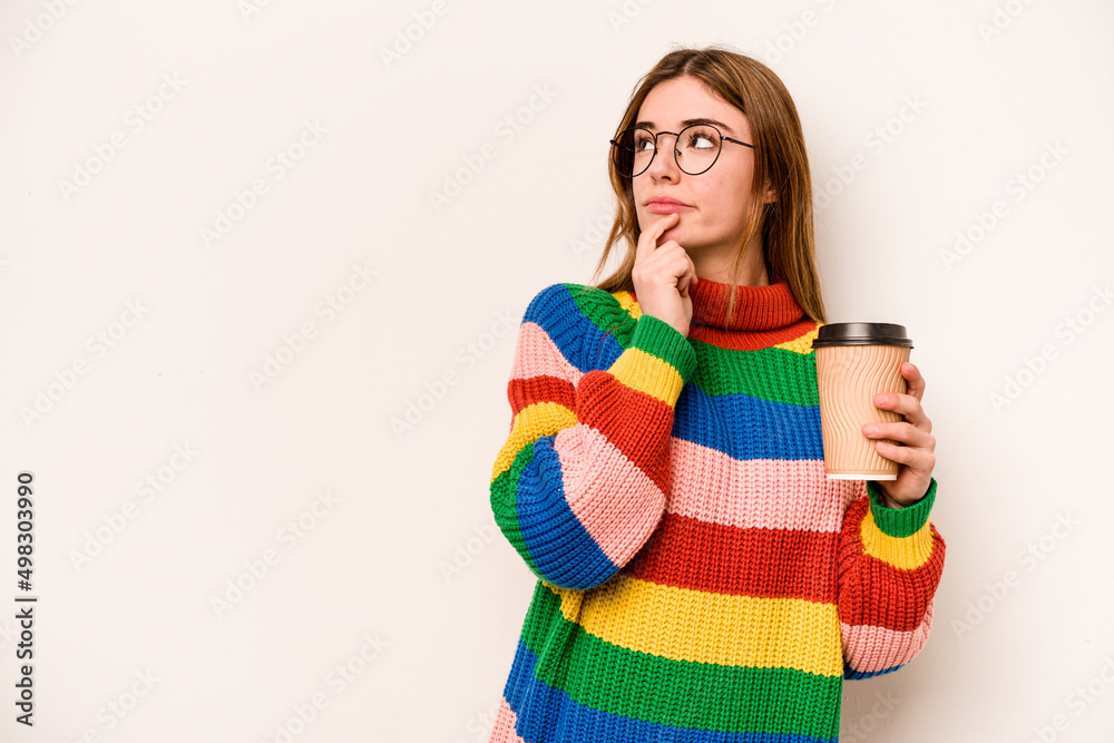 Young caucasian woman holding a take away coffee isolated on white background looking sideways with doubtful and skeptical expression. Young caucasian woman holding a take away coffee isolated on white background looking sideways with doubtful and skeptical expression.