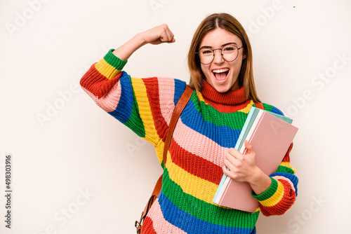 Young student caucasian woman isolated on white background raising fist after a victory  winner concept.