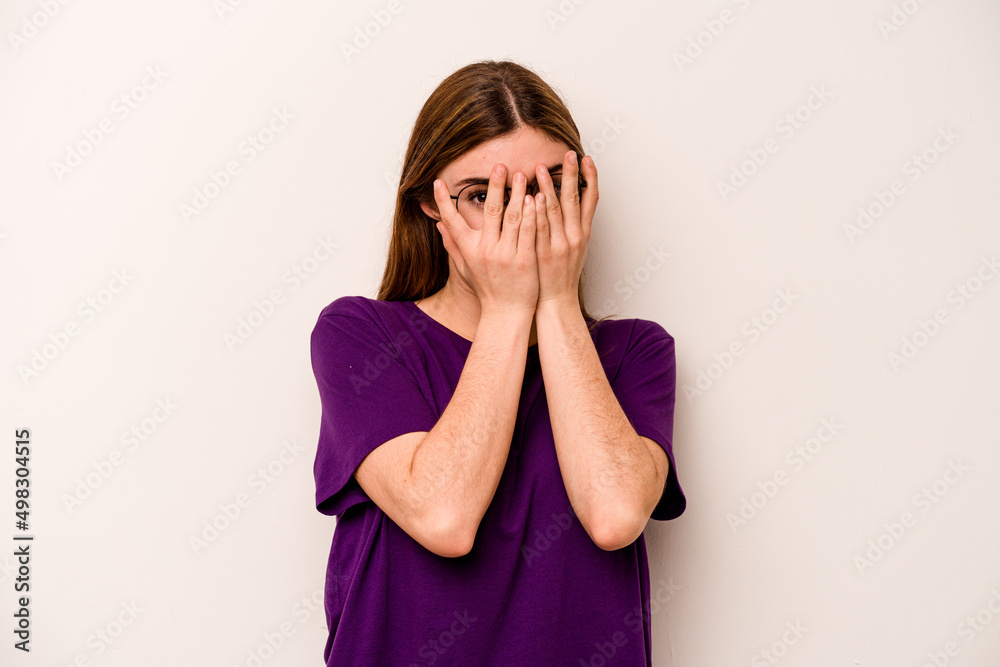 Young caucasian woman isolated on white background blink through fingers frightened and nervous. Young caucasian woman isolated on white background blink through fingers frightened and nervous.