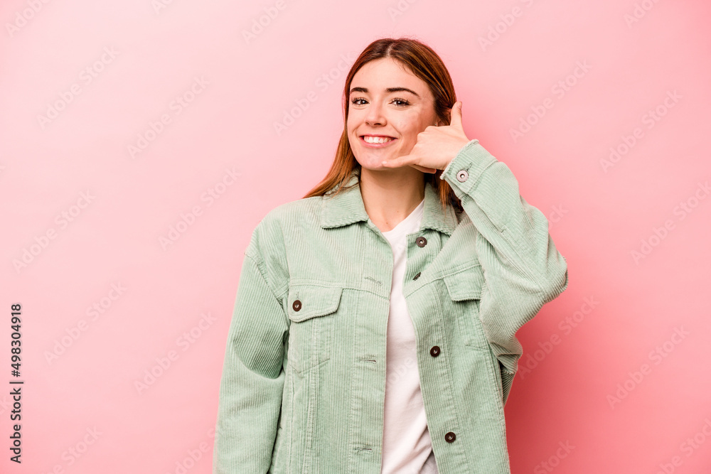Young caucasian woman isolated on pink background showing a mobile phone call gesture with fingers. Young caucasian woman isolated on pink background showing a mobile phone call gesture with fingers.