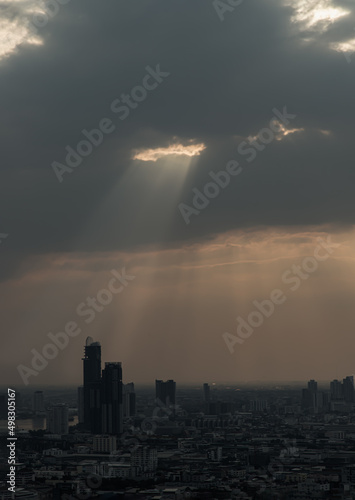 The sun's rays passing through the clouds and illuminate skhining down over the skyscraper of bangkok. Hole lighting selecting.