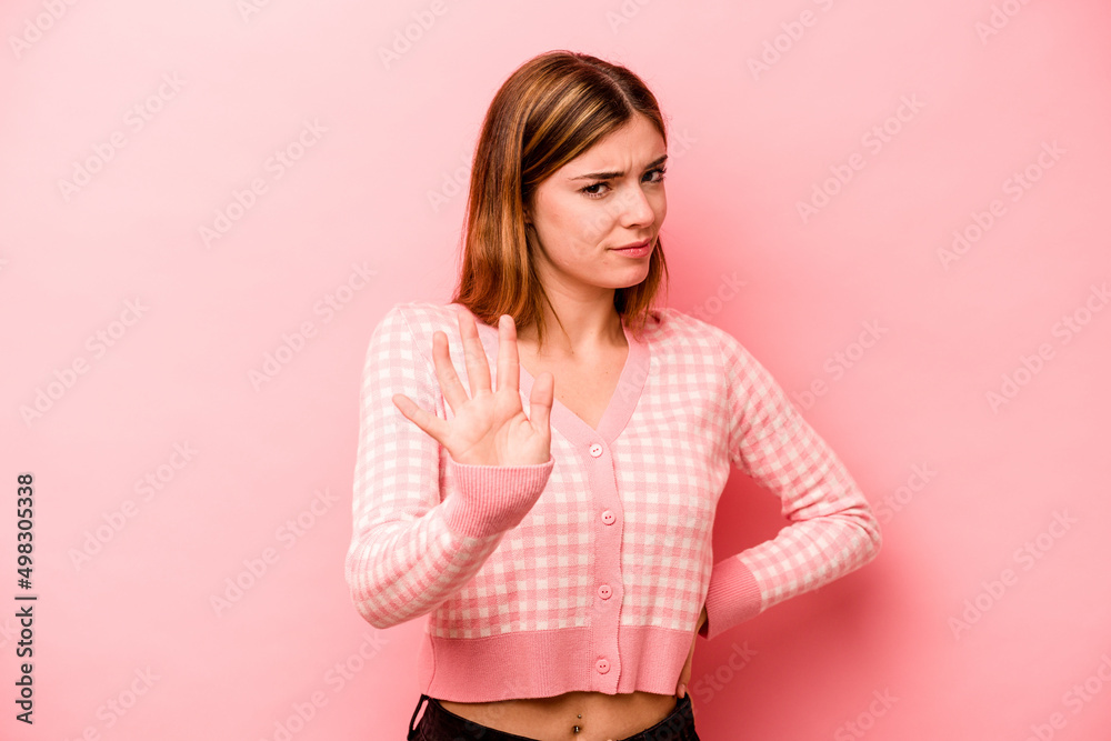 Obraz premium Young caucasian woman isolated on pink background rejecting someone showing a gesture of disgust.