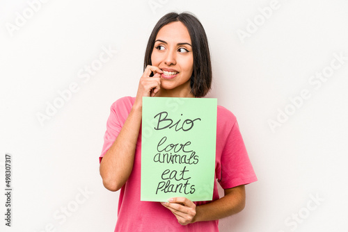 Young hispanic woman holding bio placard isolated on white background relaxed thinking about something looking at a copy space.