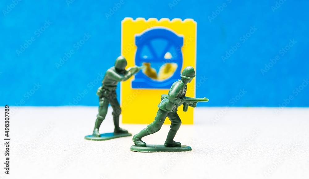 Obraz premium Plastic Toy Soldiers in the heat of battle, with a window in the backdrop and plastic soldiers inside