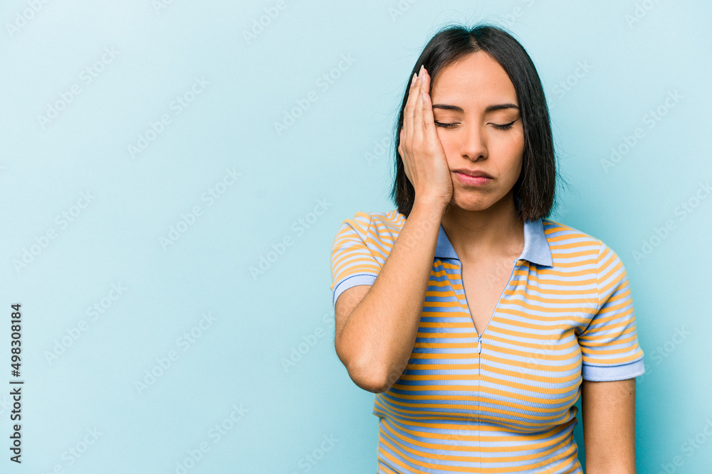 Young hispanic woman isolated on blue background who feels sad and pensive, looking at copy space. Young hispanic woman isolated on blue background who feels sad and pensive, looking at copy space.