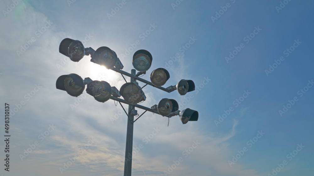 Aerial with light tower of a football stadium from above. HDR depiction of lights pole. Soccer stadium flashlights. Seasonal sport concept.
