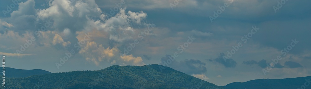 Sunset sky over themountains. Panoramic view of the mountains  at sunset. The beautiful sky and white clouds over mountains, the landscape in Carpathian Mountains, Ukraine.  Tourism and travel concept