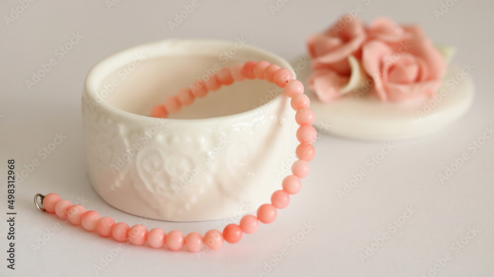 Pink coral bracelet and porcelain jewelry box isolated on white background, on table. Pink coral bracelet and porcelain jewelry box isolated on white background, on table.