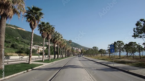 View of the boulevard road among the palm trees and the sea in Vlore, Albania photo