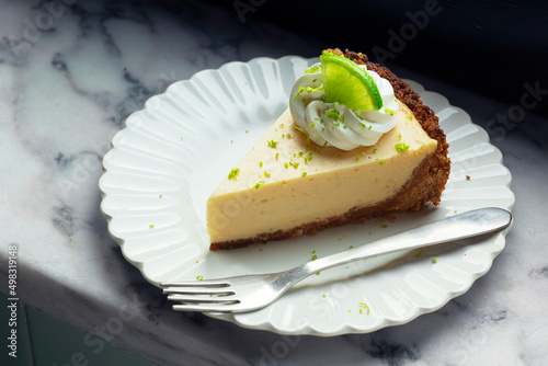 Slice of Key Lime Pie with Whipped Cream and Lime Zest on a Plate