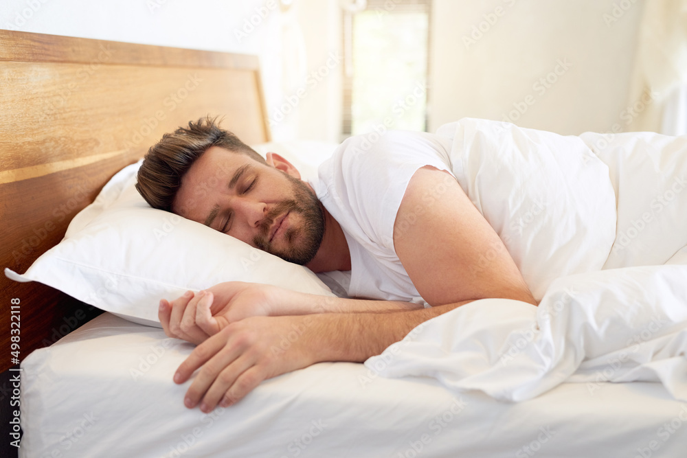 Time to enjoy a weekend lie-in. Cropped shot of a young man sleeping peacefully in bed at home. Time to enjoy a weekend lie-in. Cropped shot of a young man sleeping peacefully in bed at home.
