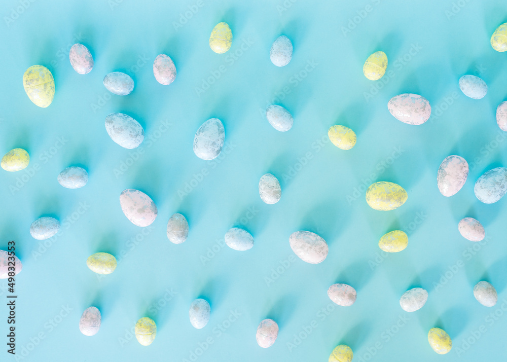 Easter concept. Multicolored pastel eggs on a blue background. Top view.