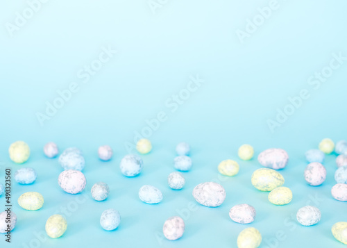 Easter concept. Multicolored pastel eggs on a blue background. 