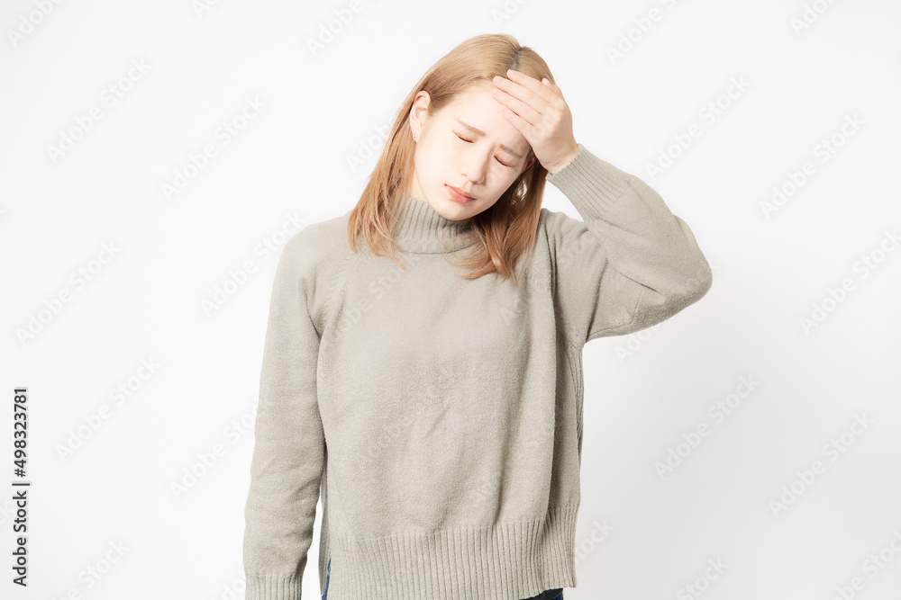 体調が悪くて頭に手を当てる若い女性 体調が悪くて頭に手を当てる若い女性