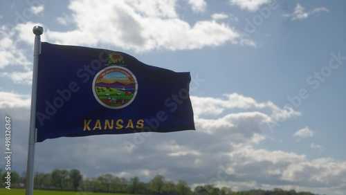 Kansas flag on a flagpole waving in the wind in the sky. State of Kansas in The United States of America