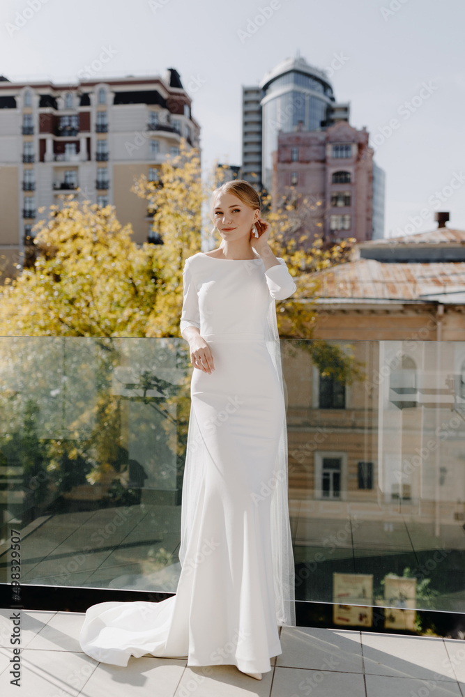  Vertical portrait of a l full-length bride on the balcony
