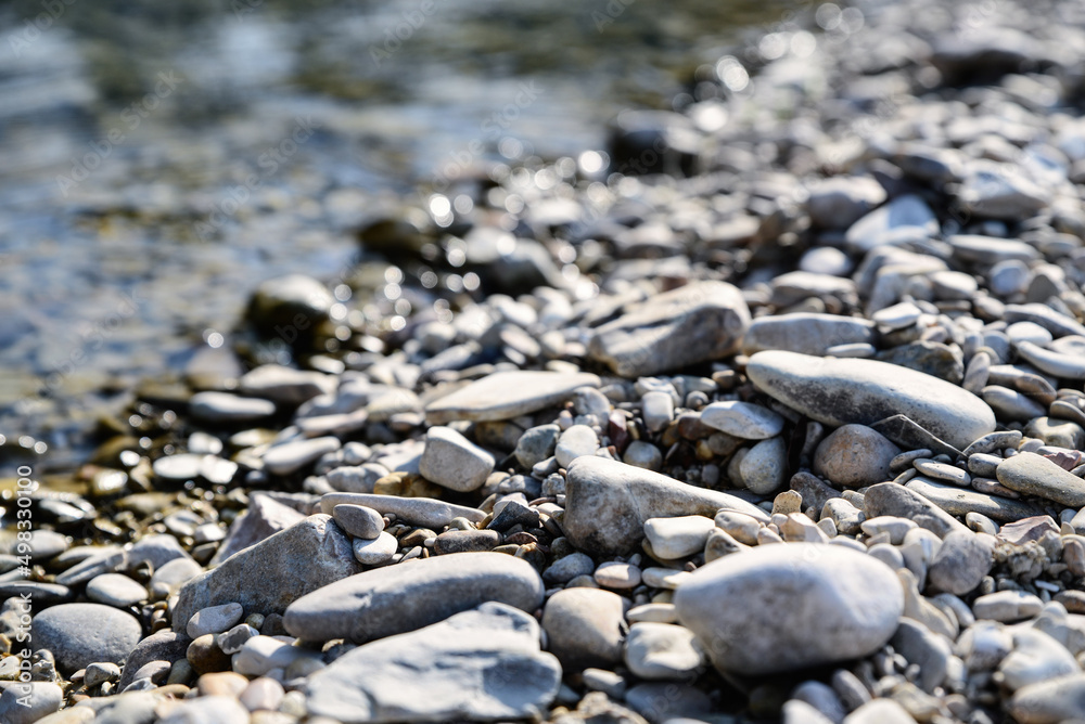 River coast with stones and pebbles on sunny day River coast with stones and pebbles on sunny day