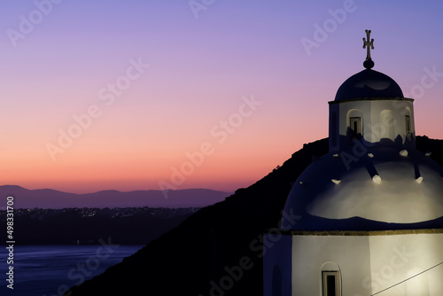 View of a traditional Greek church in Santorini and an amazing purple sunset