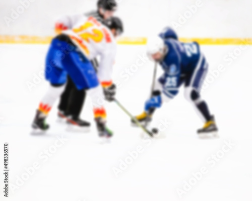 Defocused confrontation of hockey players on ice during the match - referee throwing the puck on point - rivalry in sports © andrey gonchar