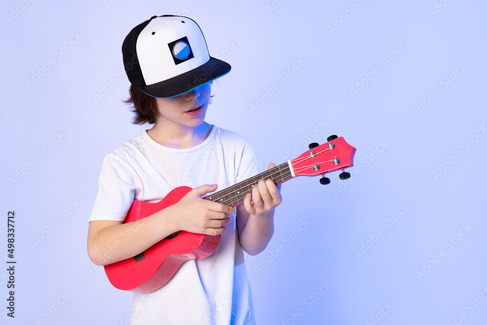 Cool school boy playing ukulele. Developing children's music lessons Cool school boy playing ukulele. Developing children's music lessons