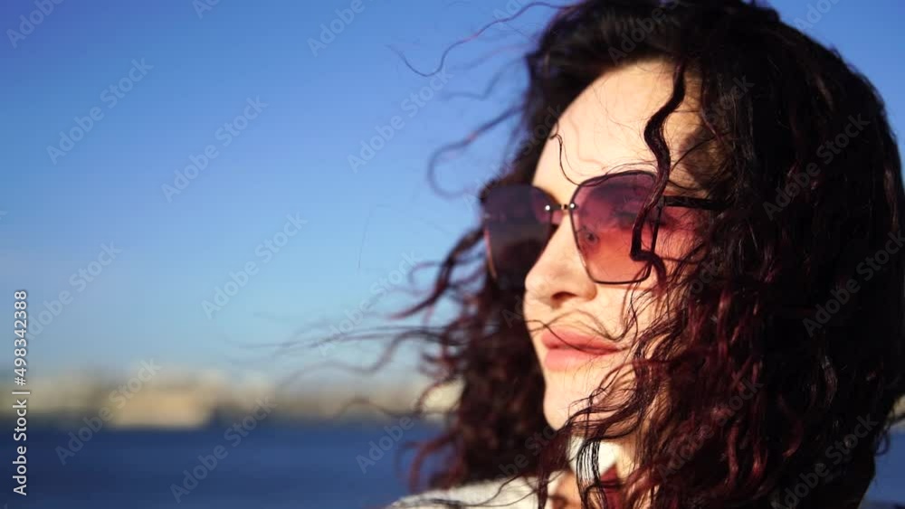 Portrait of a middle-aged woman with dark hair of European appearance, whose hair is developing against the sea. Portrait of a middle-aged woman with dark hair of European appearance, whose hair is developing against the sea.