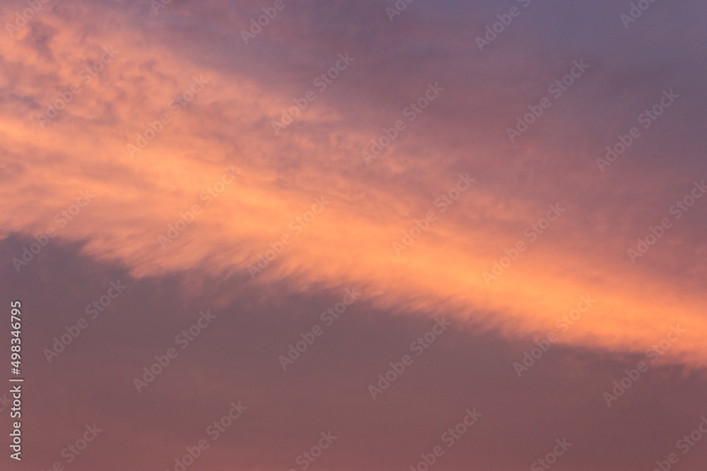 glowing clouds on the red sky in evening light. dramatic weather in summer at dusk