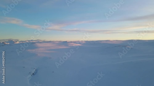 The flight above snowfield in rose sunlight