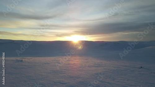 The flight above snowfield towards sun