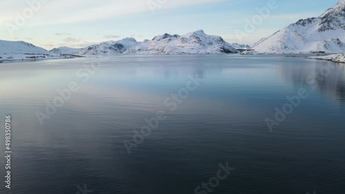 The flight above sea surrounded by mountains in winter