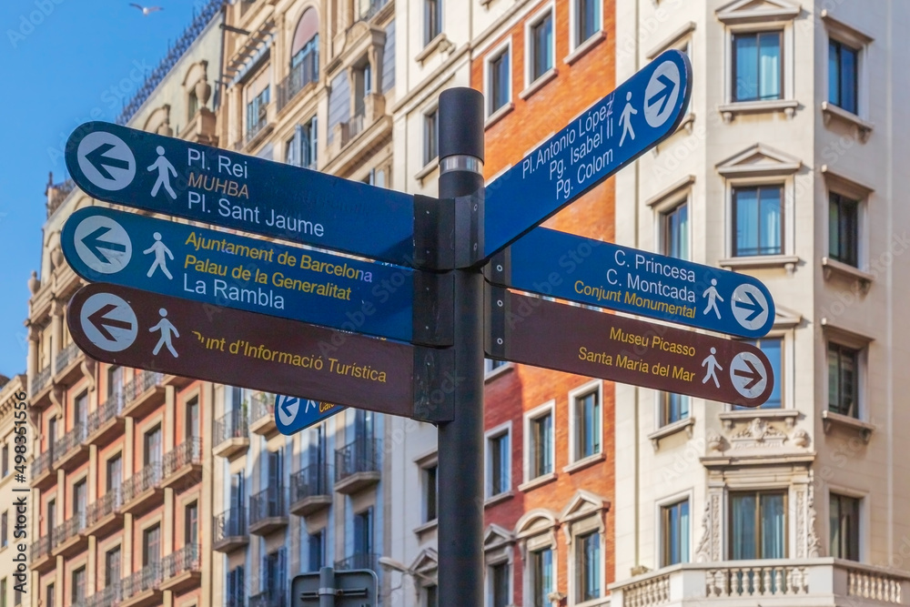 Street signs marking the direction to the famous sites to visit in Barcelona, Spain