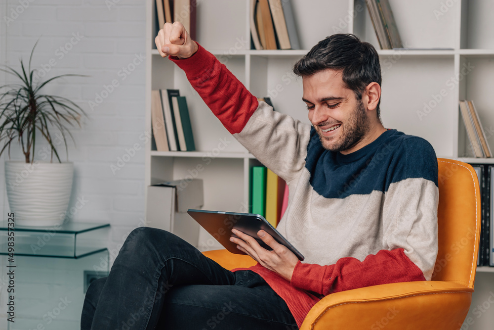 young man at home excited with happiness shopping online young man at home excited with happiness shopping online
