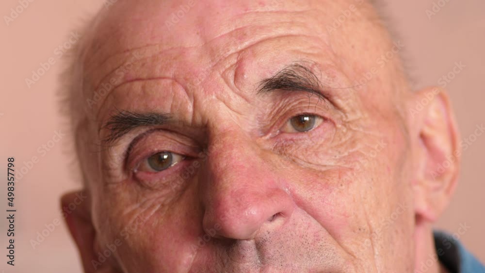 Portrait of a caucasian elderly man over 70 looking at the camera. The face of an elderly man close-up. Real people, an elderly man with deep wrinkles. slow motion.selective focus Portrait of a caucasian elderly man over 70 looking at the camera. The face of an elderly man close-up. Real people, an elderly man with deep wrinkles. slow motion.selective focus