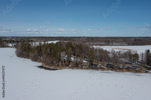 Landscape over a forest and a lake covered with ice and snow. Drone photo. Scandinavia. Finland. © M.V.schiuma