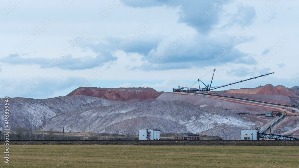 Fototapeta premium Giant spreader or absetzer machinery. A large dumper on a landfill with potash ore. Extracting potassium salts.