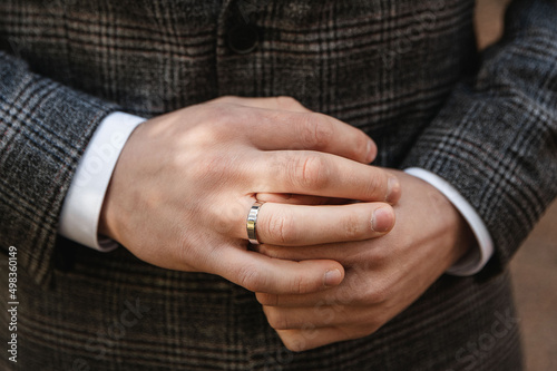 The groom holds a wedding ring on his hand. Groom, engagement, wedding