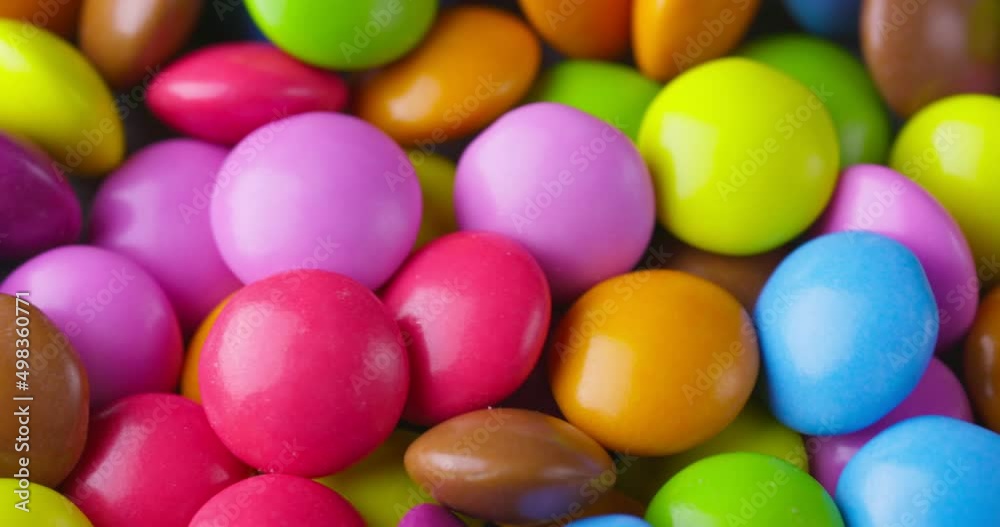 Slow motion close-up of round colorfull chocolate candies, dragee. Rotation and fall multicolored chocolate candies Slow motion close-up of round colorfull chocolate candies, dragee. Rotation and fall multicolored chocolate candies