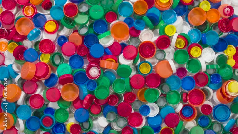 Collection and Disposal of Plastic Caps. HD Loop. A large number of multi-colored plastic milk, juice and beverage lids rotate slowly in front of the camera to symbolize sorting and recycling Collection and Disposal of Plastic Caps. HD Loop. A large number of multi-colored plastic milk, juice and beverage lids rotate slowly in front of the camera to symbolize sorting and recycling