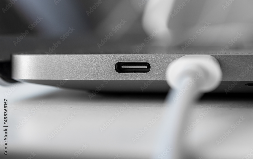 USB-C port and cable on a laptop. USB-C port and cable on a laptop.