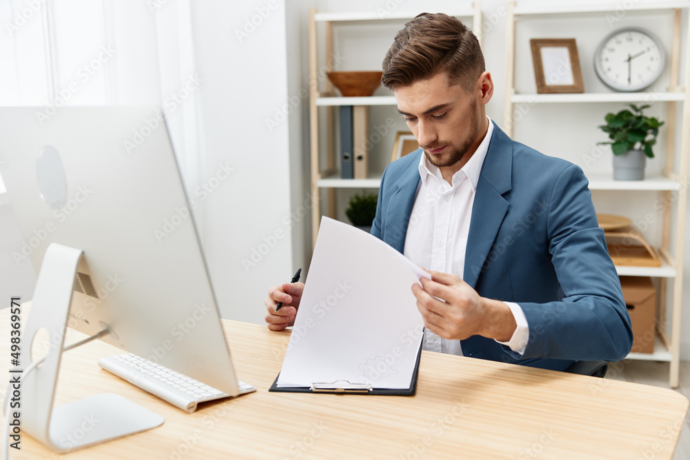 a man in a suit writes in documents at the desk in the office isolated background