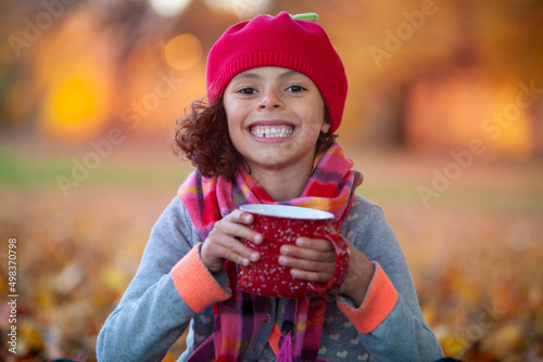 Photo Autumn scene with Cute Girl drinking hot chocolate in park