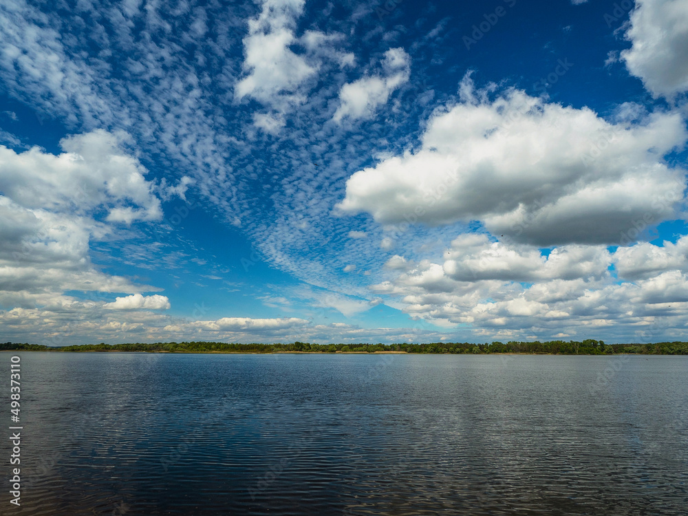 cloud landscape on a blue sky, reflected in the river