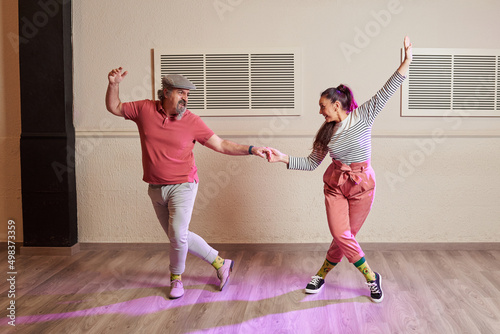 A senior adult couple dancing Lindy Hop in a studio