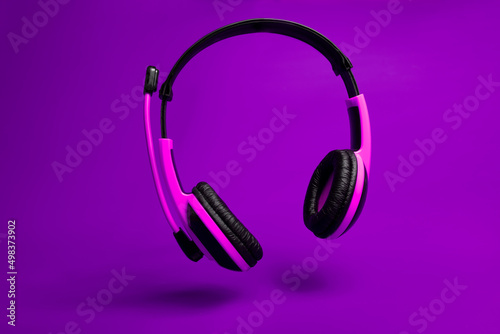 pink headphones on violet background 