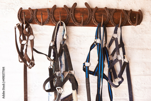 Everything in its place. Shot of riding tack hanging from a wall.