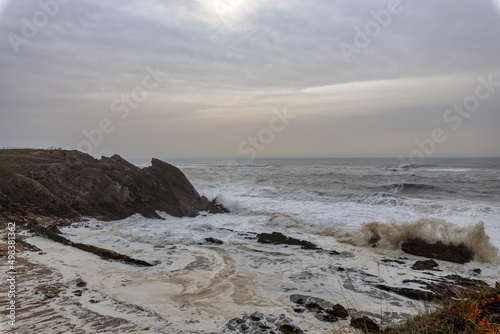 Wild Sea in Portugal near Nazare with Foamy Waves Crashing against Rocky Cliffs