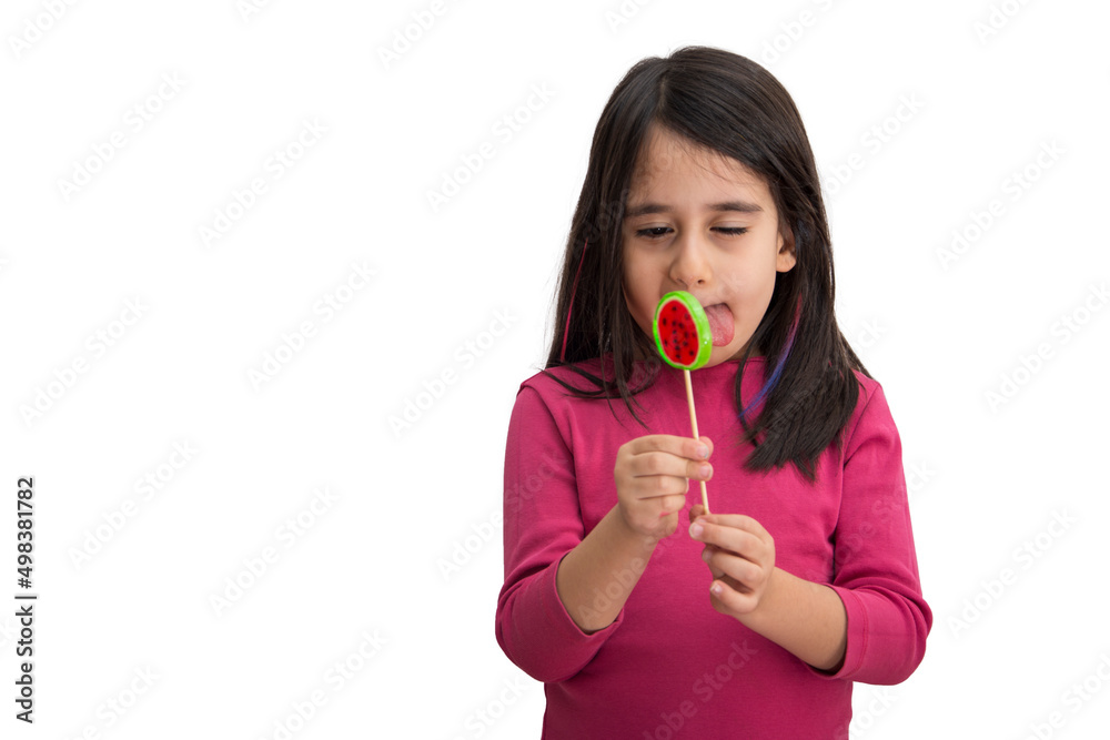 Little girl holding candy licks her lips on white background Little girl holding candy licks her lips on white background